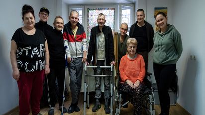 Besuch in der Unterkunft für Obdachlose. Die zum Teil ehemaligen Obdachlosen leben hier selbstorganisiert.Gruppenaufnahme in dem Andachtsraum in der Unterkunft für Obdachlose. Natalia (1. Person v. links, 60 Jahre), die Köchin, Nik (Person Mitte, stehend mit Rollator) die gute Seele der Unterkunft, Vitali (2. Person v. links) arbeitet mit viel Erfahrung als Betreuer in der Unterkunft und Olga (1. Person v. rechts) ist Betreuerin und Krankenschwester in der Unterkunft. Projektpartner: House of Mercy