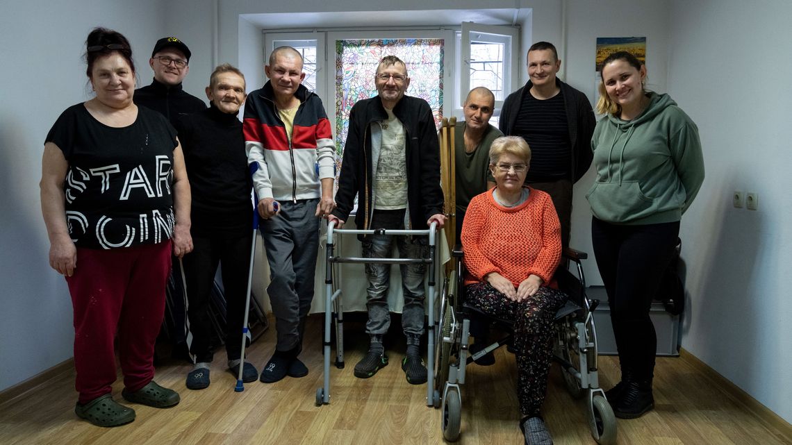 Besuch in der Unterkunft für Obdachlose. Die zum Teil ehemaligen Obdachlosen leben hier selbstorganisiert.Gruppenaufnahme in dem Andachtsraum in der Unterkunft für Obdachlose. Natalia (1. Person v. links, 60 Jahre), die Köchin, Nik (Person Mitte, stehend mit Rollator) die gute Seele der Unterkunft, Vitali (2. Person v. links) arbeitet mit viel Erfahrung als Betreuer in der Unterkunft und Olga (1. Person v. rechts) ist Betreuerin und Krankenschwester in der Unterkunft. Projektpartner: House of Mercy